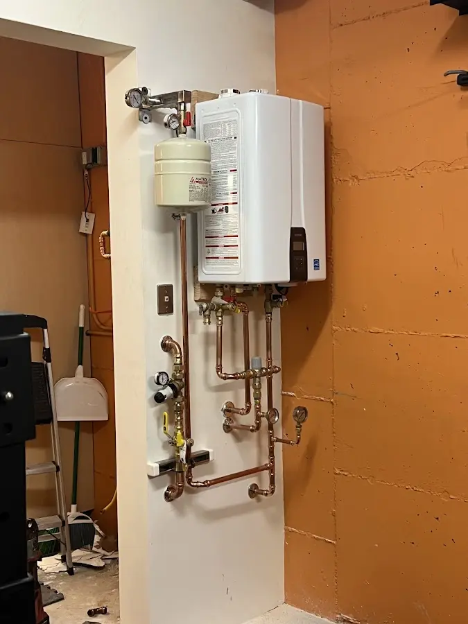 Plumbing technician inspecting water heater connections in Detroit Lakes